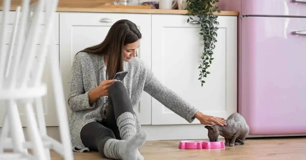 Woman practicing asthma self-care in a safe and cozy home environment as her cat eats nearby.